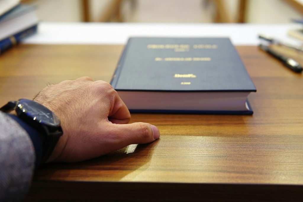 Abogada Autónoma Barcelona - person holding black covered book on brown wooden table
